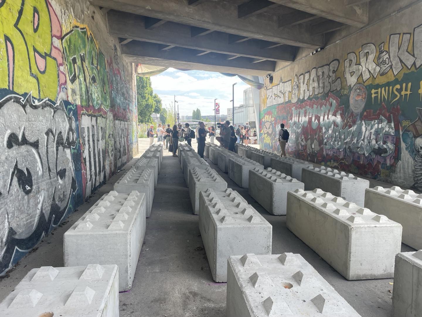 Photo of what was previously a homeless encampment beneath an underpass in Paris, France, now cleared of unhoused residents and filled with large cement blocks with anti-sitting spikes on top of them. Photo taken by Dave Zirin on July 24, 2024.