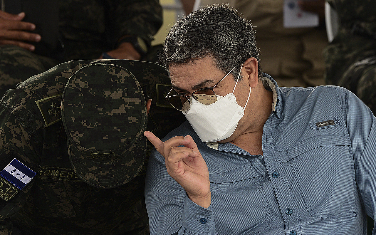 Honduran President Juan Orlando Hernandez gives instructions to an army colonel, after delivering a speech during the eighth anniversary of the Military Police of Public Order (PMOP) in Tegucigalpa, on August 24, 2021. Photo by ORLANDO SIERRA/AFP via Getty Images