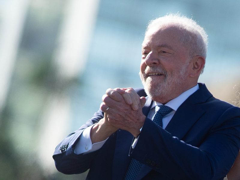 Man in suit clasps his hands together