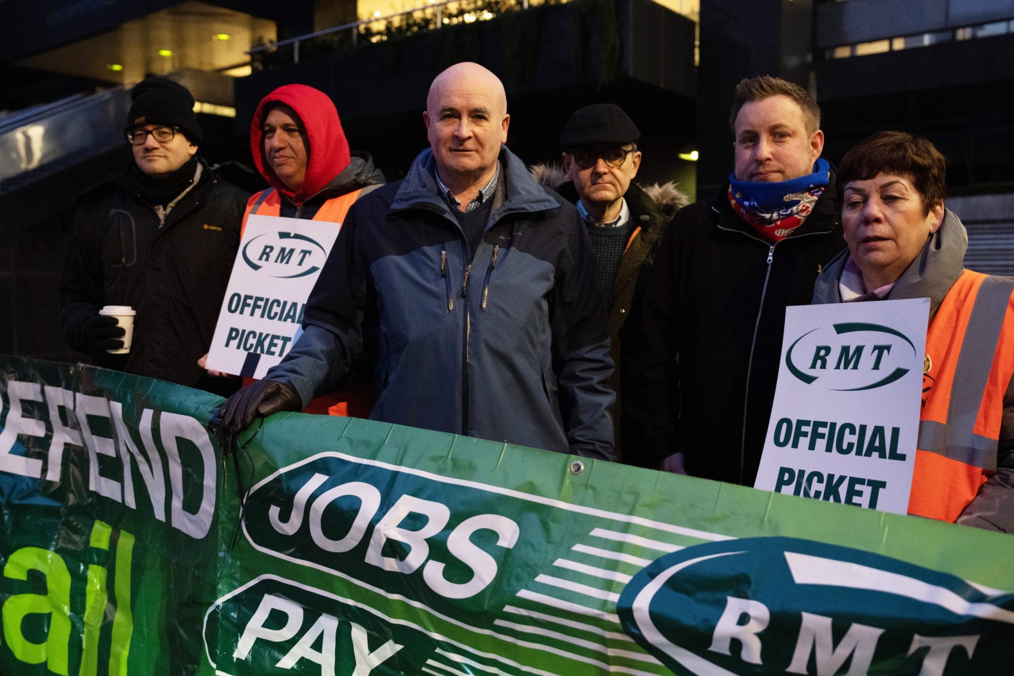 Mick Lynch (C), general secretary of the Rail, Maritime, and Transport Workers union, stands on a picket line with union members outside Euston Station on January 3, 2023, in London, England.