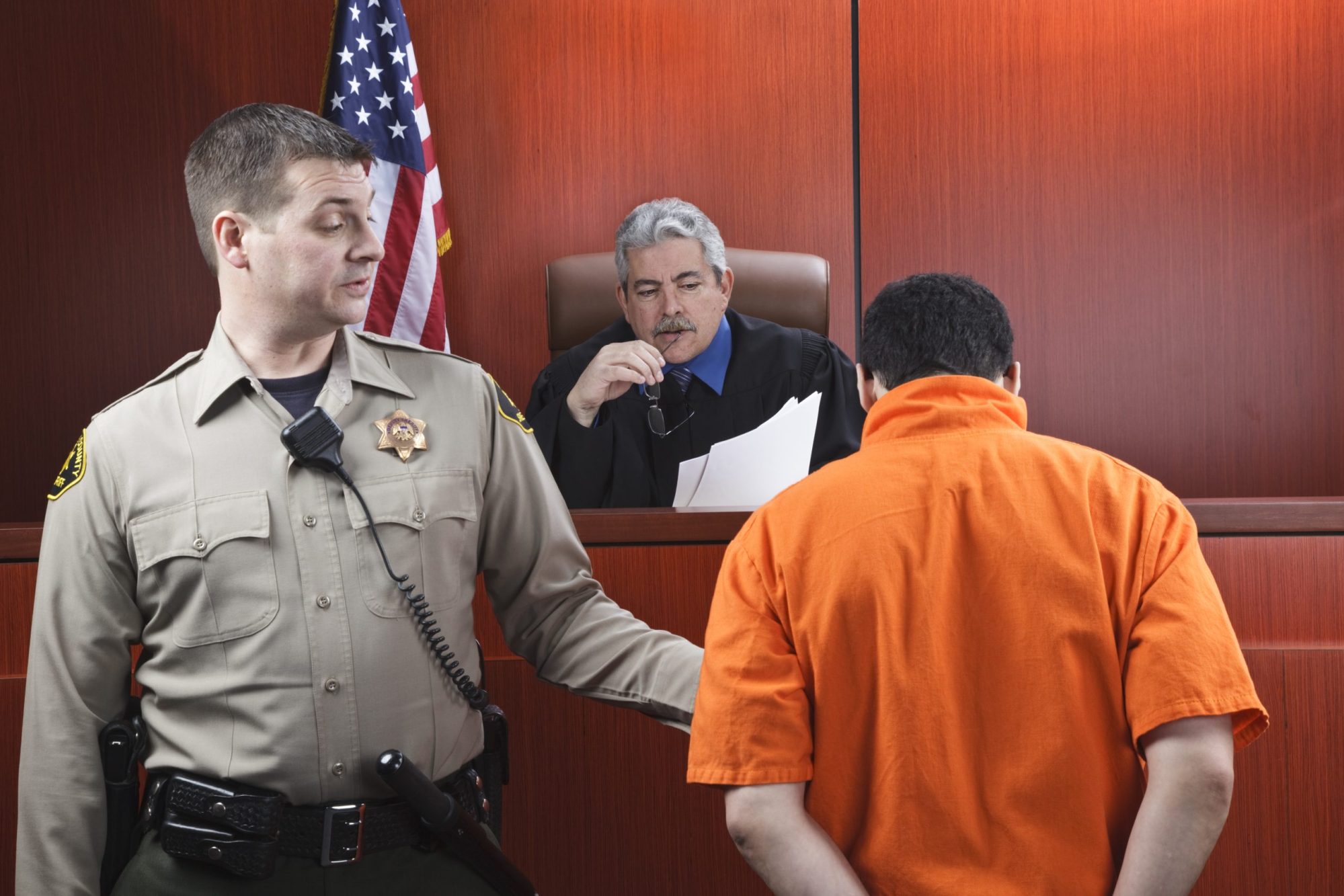 Judge speaking to a prisoner in the courtroom.