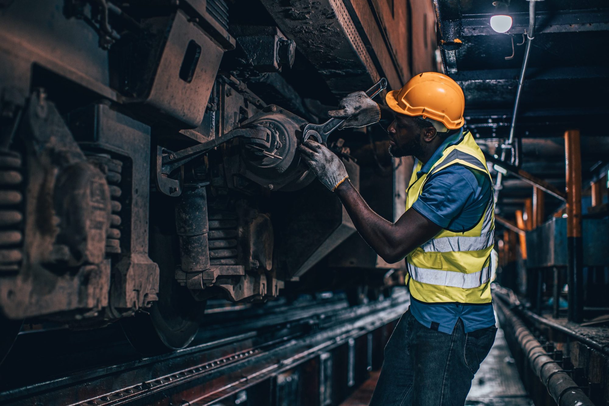 one man worker servicing replace broken part of old train at diesel locomotive repair shops via Getty Images