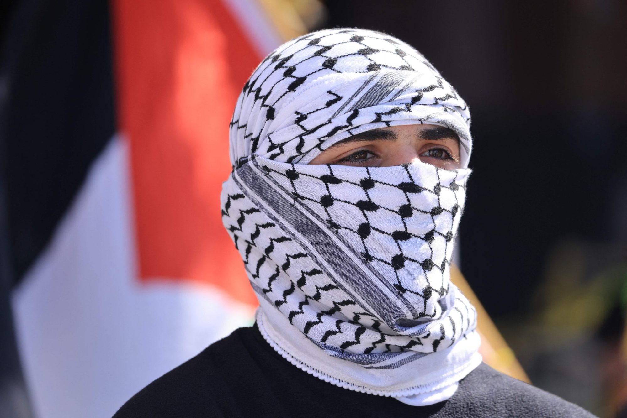 A protestor wears a Palestinian keffiyeh as he joins thousands of demonstrators waving Palestinian flags and signs denouncing "Israeli apartheid" during a march in support of Palestinians in Los Angeles on October 14, 2023. Photo by DAVID SWANSON/AFP via Getty Images