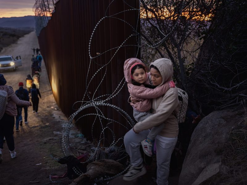 Migrants cross through a gap in the US-Mexico border fence on January 3, 2024 in Jacumba Hot Springs, San Diego, California. Photo by Qian Weizhong/VCG via Getty Images