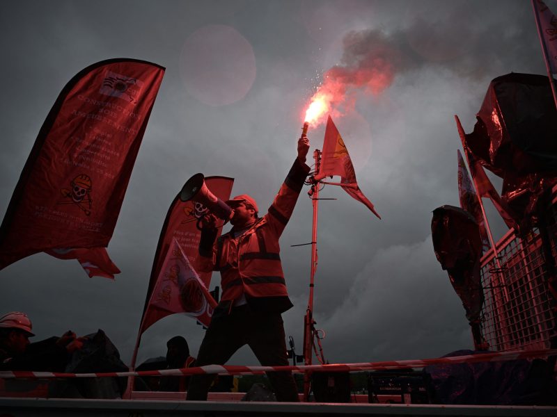 A protester on a CGT trade union truck speaks through a megaphone as he holds a burning flare during a May Day (Labour Day) rally, marking International Workers' Day, in Bordeaux, southwestern France, on May 1, 2024. Photo by PHILIPPE LOPEZ/AFP via Getty Images