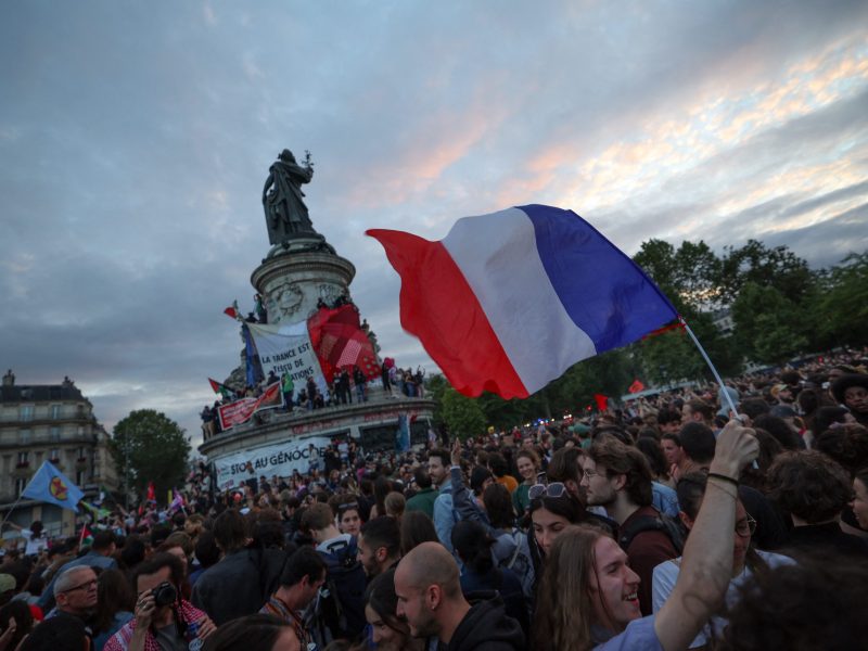 A participant waves a French national tricolor during an election night rally following the projected results of the second round of France's legislative election, at Place de la Republique in Paris on July 7, 2024. Photo by EMMANUEL DUNAND/AFP via Getty Images