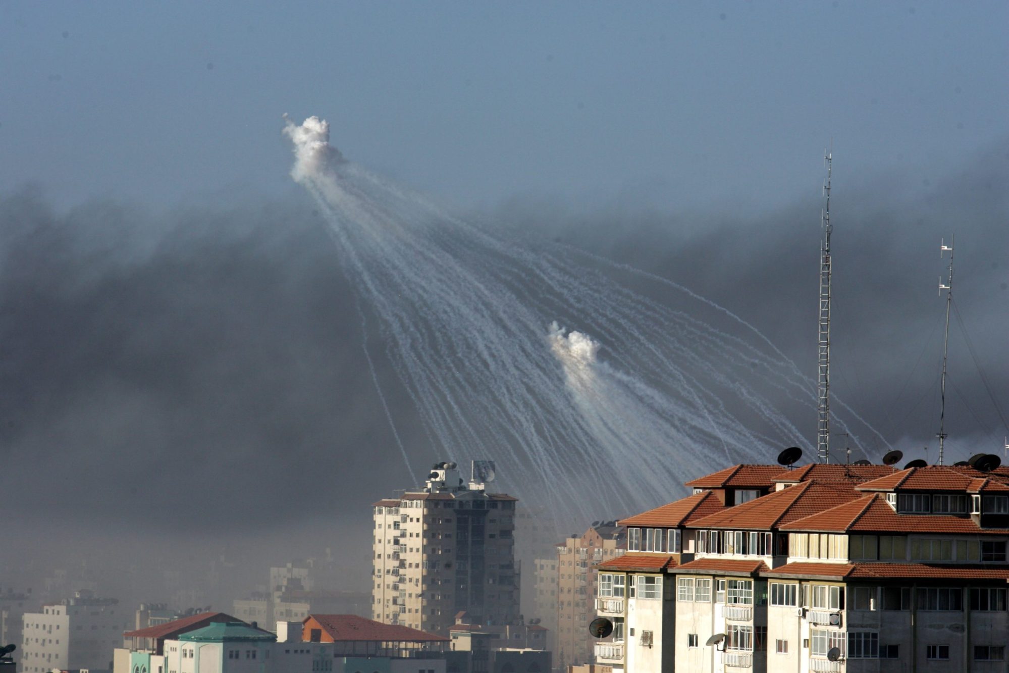 Smoke rises from the United Nation headquarters after an Israeli air force strike as Israeli artillery shells explode over the area on January 15, 2009 in the center of Gaza city, Gaza Strip. Photo by Abid Katib/Getty Images