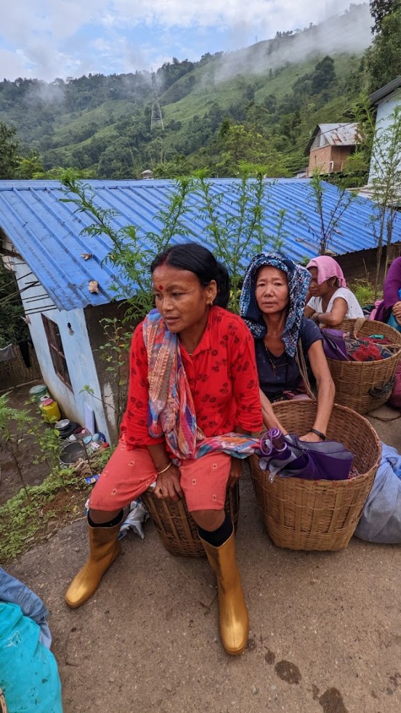 Women tea workers sit on or near their tea baskets outside on the Chongtong Tea Estate in Darjeeling, India, on October 13, 2022. 