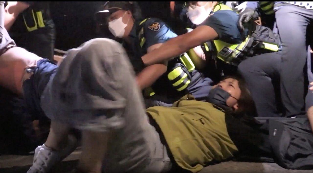 A South Korean protestor nonviolently resists arrests by police during a sit-in against the construction of the US military's THAAD missile system. Screenshot taken from video by Son So-hee and Min.