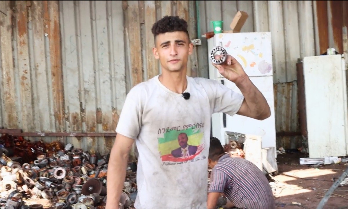 A worker at an e-waste recycling factory in Idhna, West Bank, shows a piece of electronic waste. Screenshot taken from video by Ahmad Al-Bazz